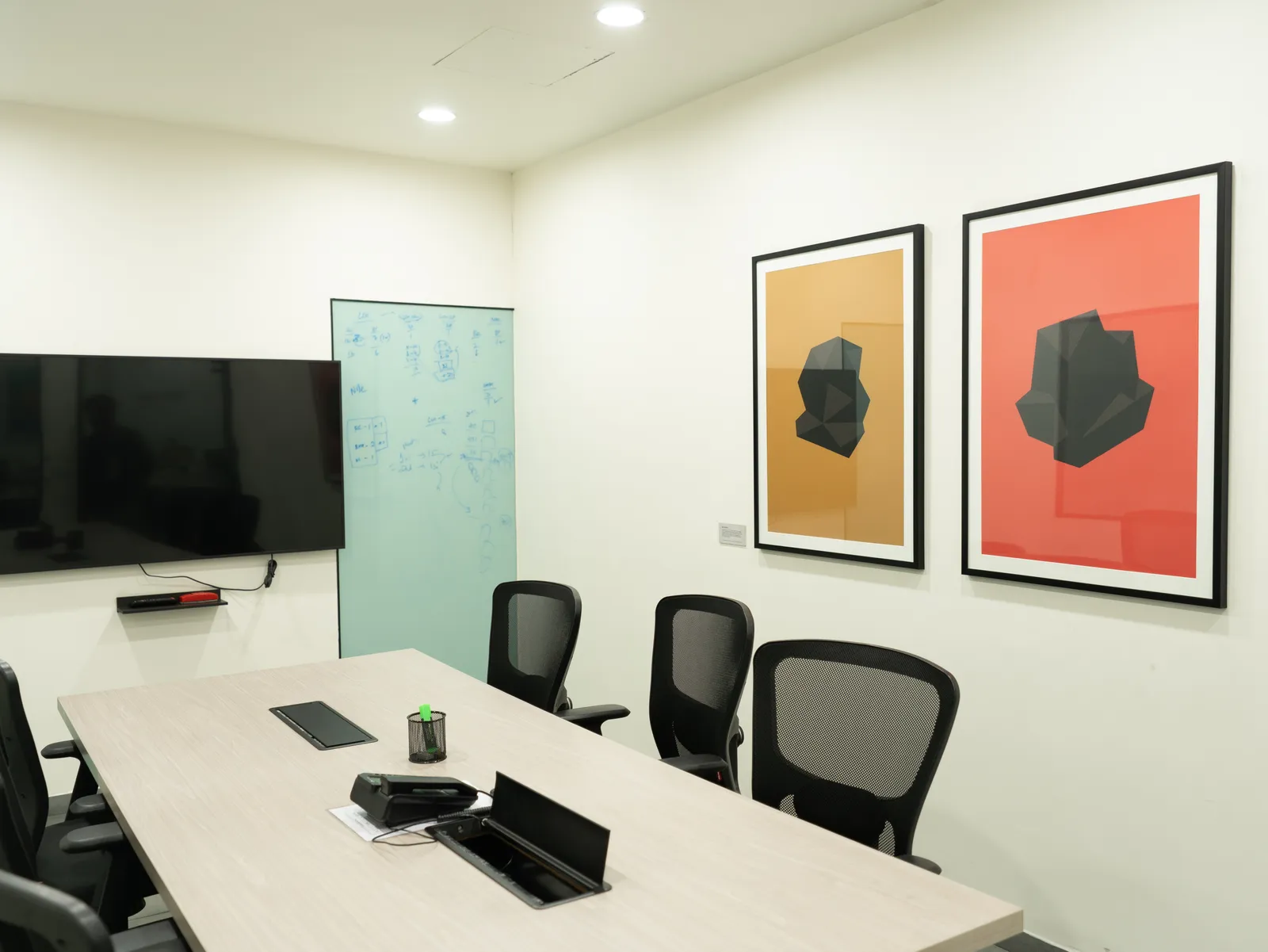 Conference room with framed art and display screen — LICO
